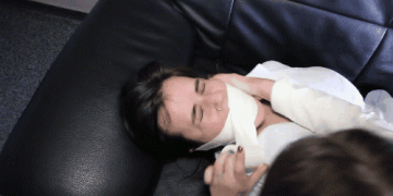 Woman gets medical microfoam tape gagged on the sofa