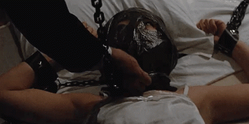 Japanese woman ball gagged and chained in bed