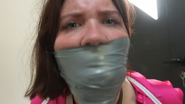 Animated gif showing a heavily tape gagged woman as she tries to talk with her mouth fully stuffed being a strict silver tape wrap gag.